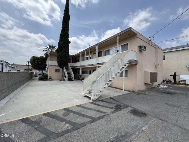 back of house featuring stairway and stucco siding