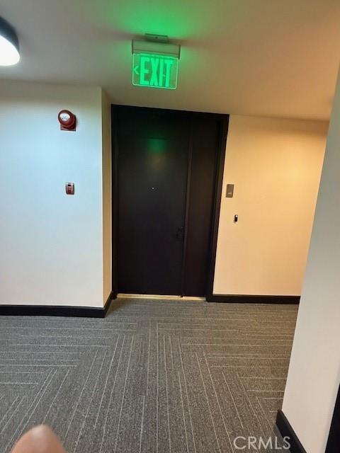 321 S San Vicente Blvd S Unit 402, Los Angeles, CA 90048 - hallway with baseboards and dark carpet