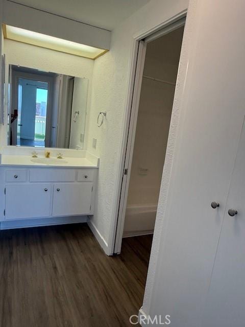 321 S San Vicente Blvd S Unit 402, Los Angeles, CA 90048 - full bath with baseboards, a tub to relax in, vanity, wood finished floors, and a textured wall