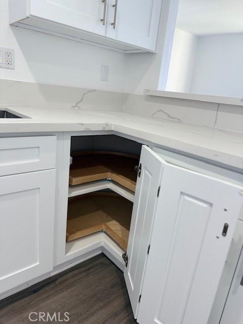 321 S San Vicente Blvd S Unit 402, Los Angeles, CA 90048 - details featuring white cabinetry, light stone counters, and dark wood-style floors