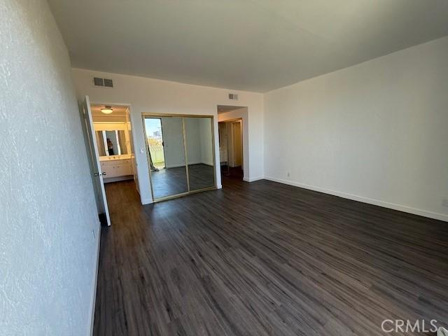 321 S San Vicente Blvd S Unit 402, Los Angeles, CA 90048 - unfurnished bedroom with baseboards, a closet, dark wood-style floors, and visible vents
