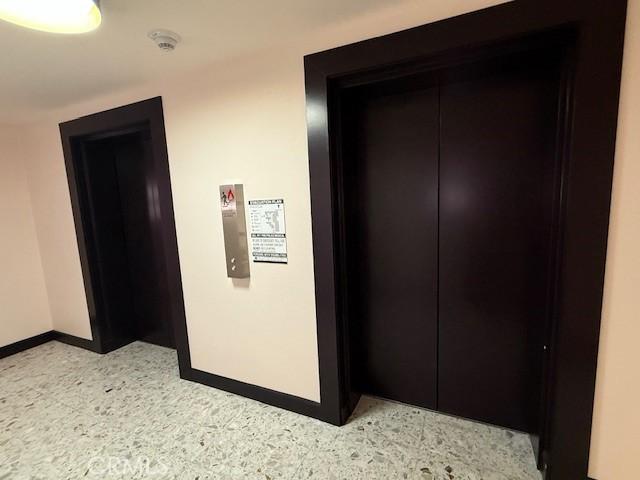 321 S San Vicente Blvd S Unit 402, Los Angeles, CA 90048 - hallway featuring baseboards, elevator, and light speckled floor