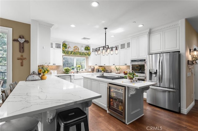 1405 Rock Ridge Dr, Lake Arrowhead, CA 92352 - kitchen featuring wine cooler, a kitchen bar, white cabinetry, a peninsula, and stainless steel appliances