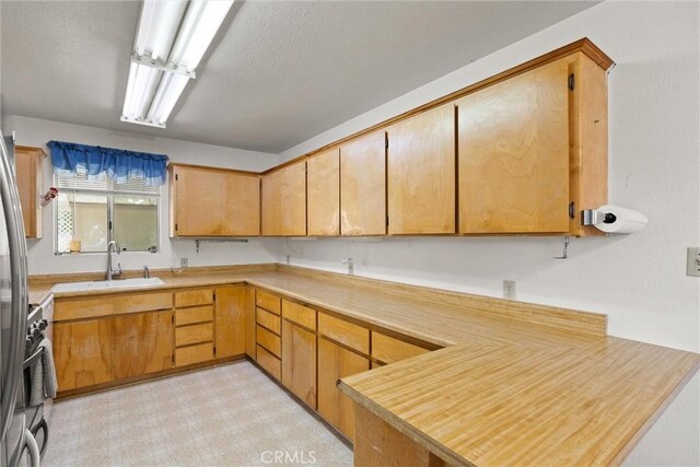 568 4th St, Willows, CA 95988 - kitchen featuring light countertops, a peninsula, a textured ceiling, and light floors