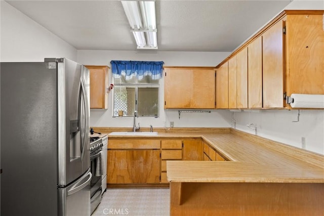 568 4th St, Willows, CA 95988 - kitchen featuring stainless steel refrigerator with ice dispenser, range with gas stovetop, a sink, a peninsula, and light countertops