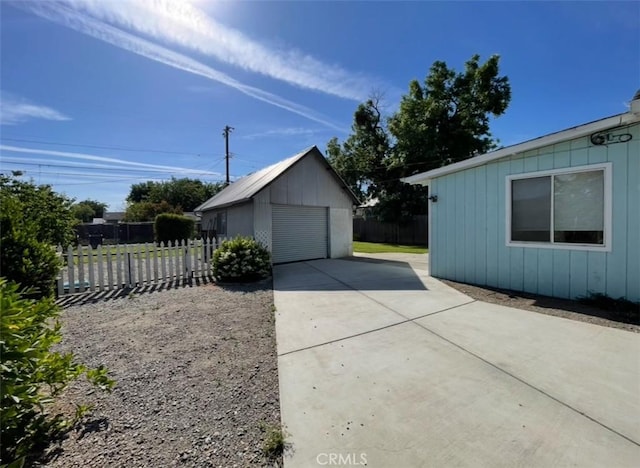 568 4th St, Willows, CA 95988 - view of side of property featuring concrete driveway, an outdoor structure, a garage, and fence