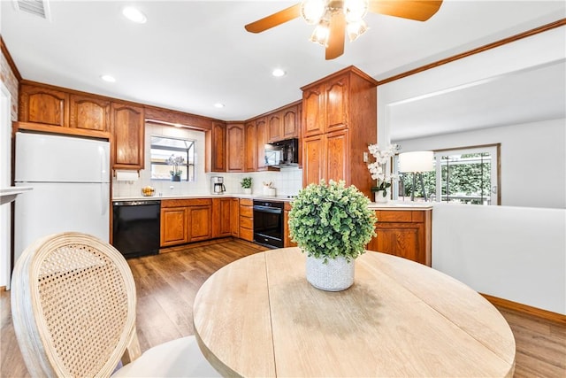 12172 Manley St, Garden Grove, CA 92845 - kitchen featuring black appliances, wood finished floors, brown cabinets, tasteful backsplash, and plenty of natural light