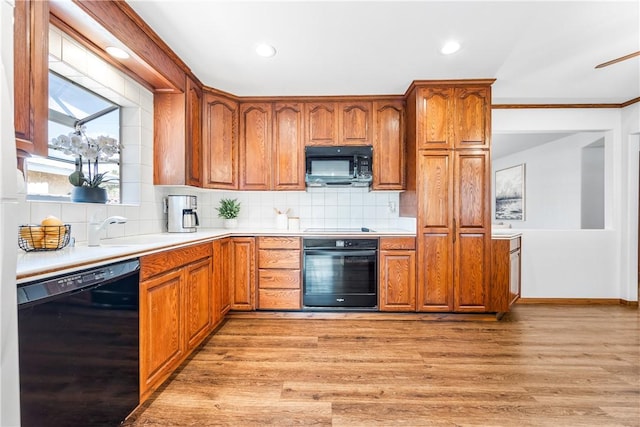 12172 Manley St, Garden Grove, CA 92845 - kitchen featuring black appliances, light countertops, light wood-type flooring, tasteful backsplash, and brown cabinets