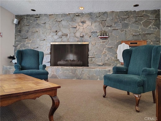 carpeted living area with a textured ceiling and a stone fireplace