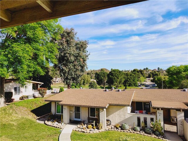 view of front of home with a front lawn, stucco siding, and a gate
