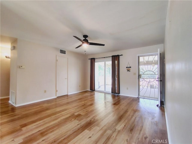 spare room with ceiling fan, light wood finished floors, and baseboards