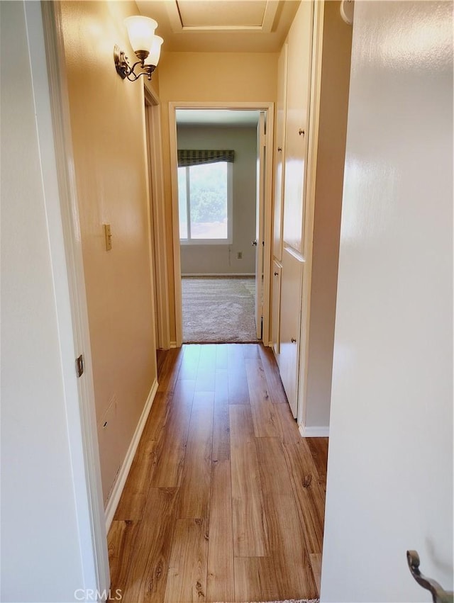 hall with light wood finished floors and baseboards
