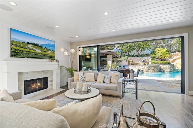 living area featuring hardwood / wood-style flooring, recessed lighting, and a tiled fireplace