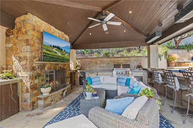 view of patio with a gazebo, an outdoor living space with a fireplace, an outdoor kitchen, area for grilling, and ceiling fan