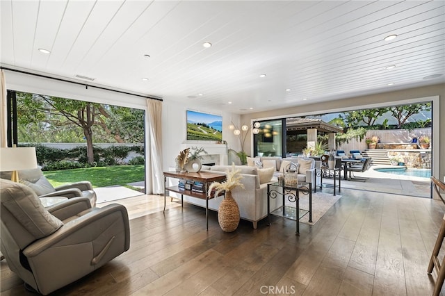 living room with plenty of natural light, hardwood / wood-style flooring, recessed lighting, and wood ceiling