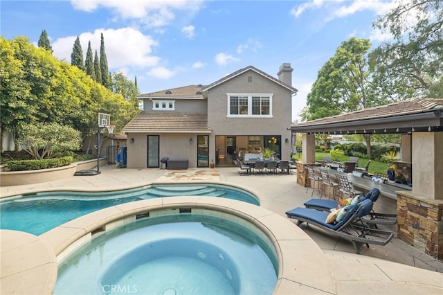 swimming pool with an in-ground hot tub and a patio area