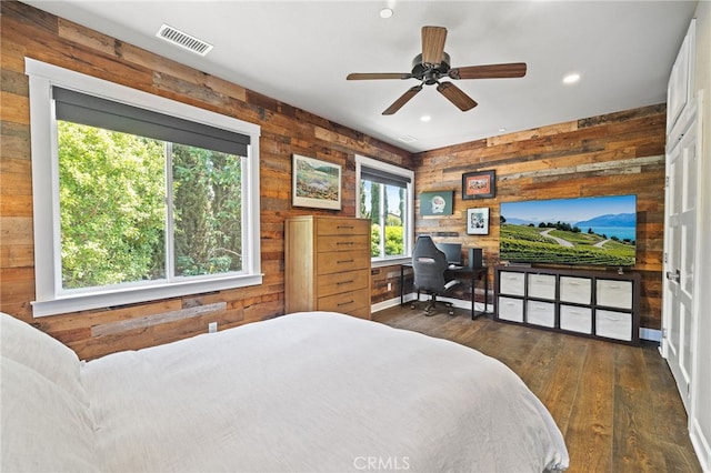 bedroom with wooden walls, dark wood-type flooring, recessed lighting, an office area, and access to outside