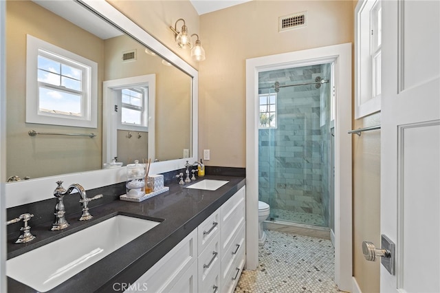 full bath featuring a stall shower, toilet, and double vanity