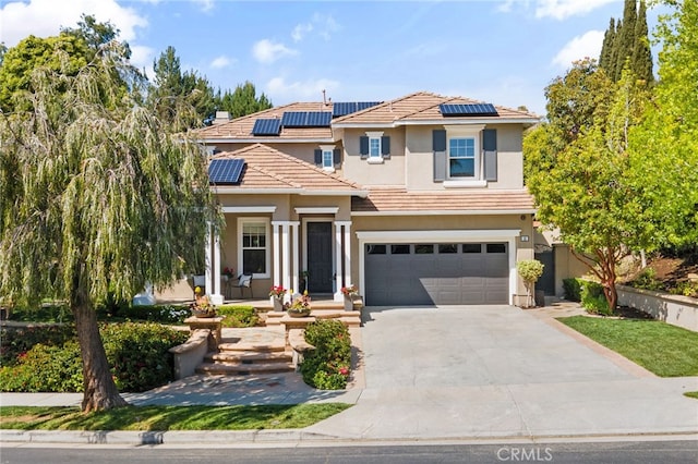 traditional-style home featuring solar panels, an attached garage, concrete driveway, a porch, and stucco siding
