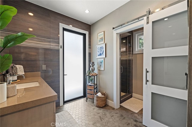 full bathroom with baseboards, a stall shower, recessed lighting, and double vanity