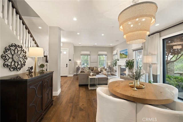 dining room with dark wood finished floors, recessed lighting, baseboards, and a chandelier