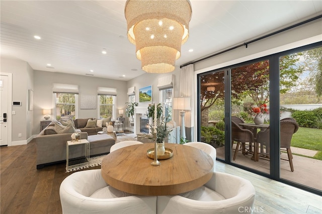 dining room with wood finished floors, recessed lighting, baseboards, and a chandelier