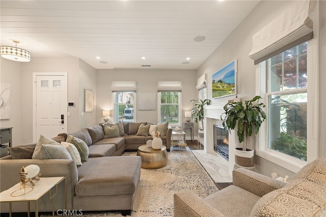 living room with a premium fireplace, wood finished floors, and recessed lighting