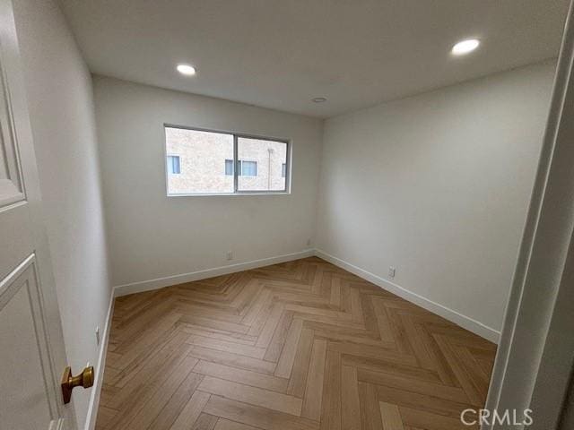 empty room featuring baseboards and recessed lighting
