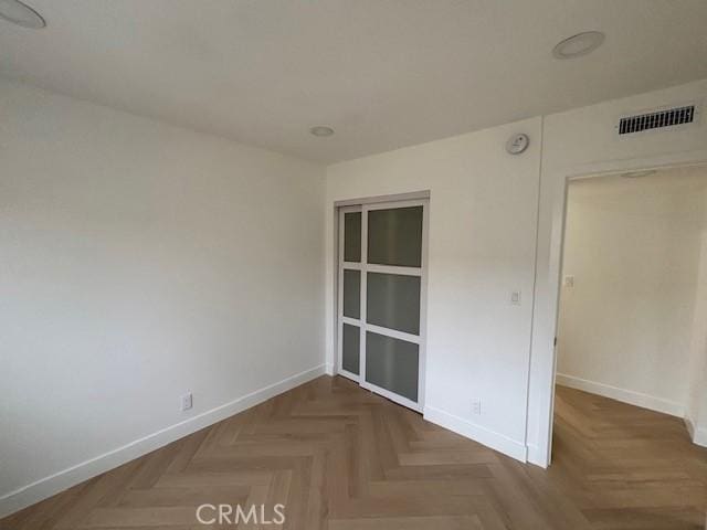 spare room featuring baseboards and visible vents