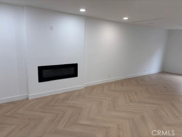 empty room with a glass covered fireplace and recessed lighting