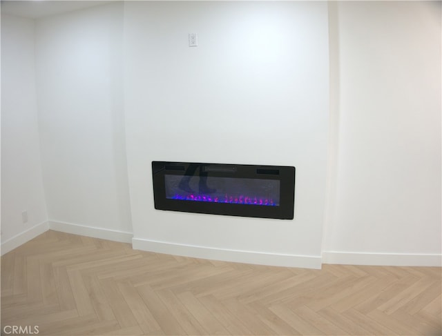 details featuring baseboards and a glass covered fireplace