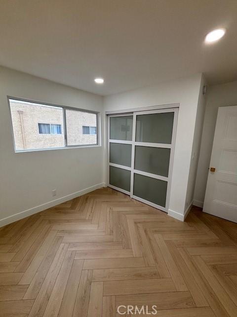 empty room featuring baseboards and recessed lighting