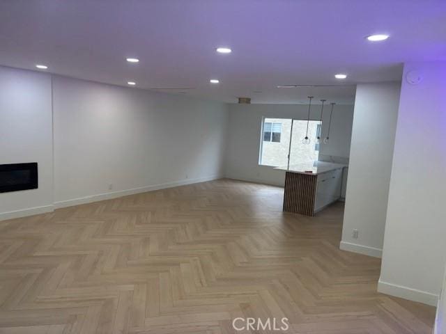 empty room featuring baseboards, a fireplace, and recessed lighting
