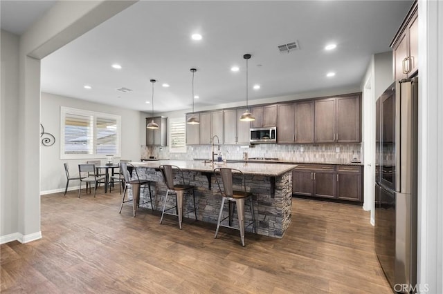 22811 Rolling Brook Ln, Wildomar, CA 92595 - kitchen featuring appliances with stainless steel finishes, decorative backsplash, a kitchen bar, dark wood-style flooring, and recessed lighting