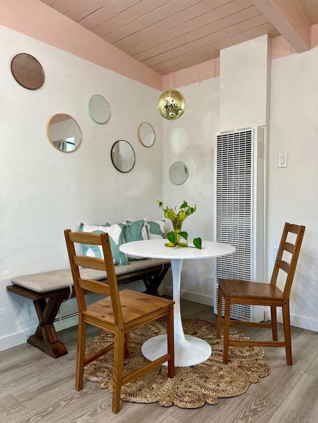 dining space with wood finished floors, breakfast area, a heating unit, baseboards, and wooden ceiling
