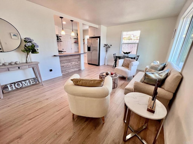 living room with baseboards and light wood finished floors