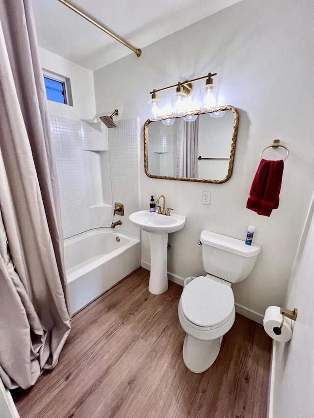 bathroom featuring shower / bath combo with shower curtain, toilet, wood finished floors, and baseboards