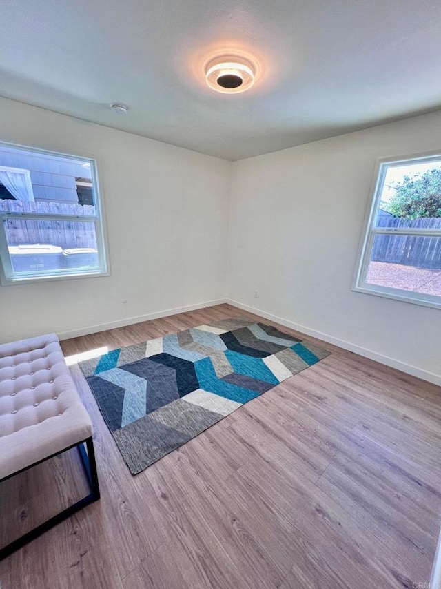 unfurnished room featuring baseboards and wood finished floors