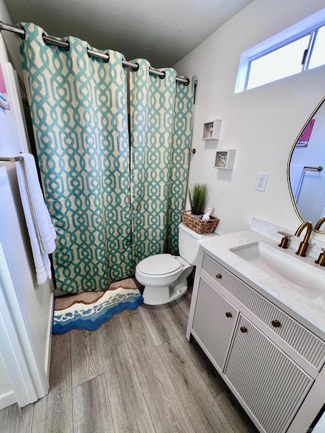 full bath with vanity, toilet, a shower with curtain, and wood finished floors