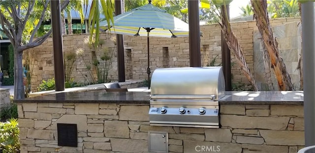 view of patio featuring a grill, visible vents, and fence
