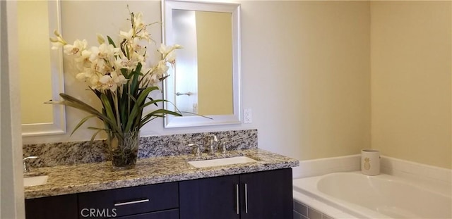 full bathroom featuring a sink, double vanity, and a bath