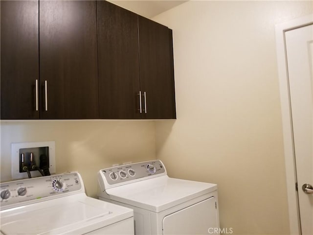 laundry area with washing machine and clothes dryer and cabinet space