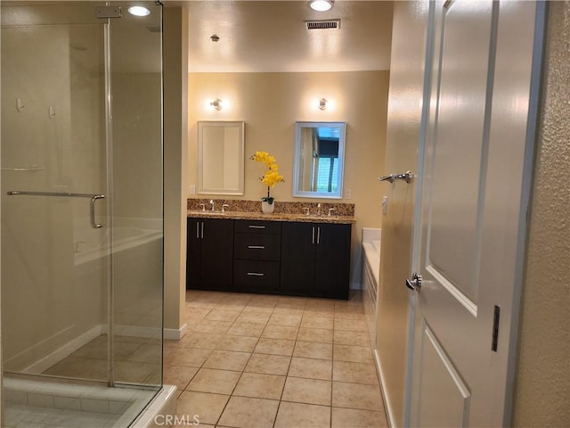 full bathroom featuring visible vents, a sink, a shower stall, tile patterned flooring, and double vanity