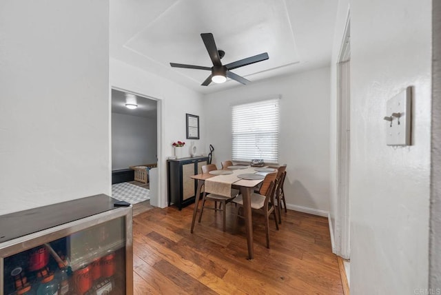 dining room featuring ceiling fan, wine cooler, and wood finished floors