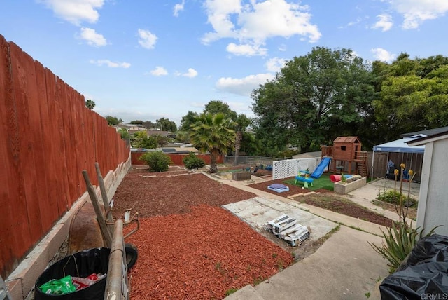 view of yard featuring a fenced backyard and a playground