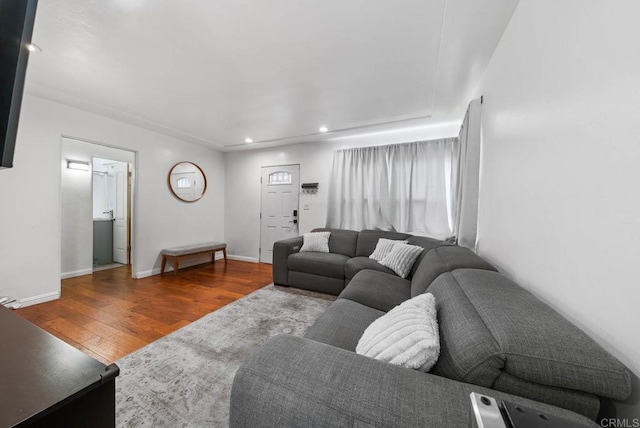 living room with wood finished floors, baseboards, and recessed lighting