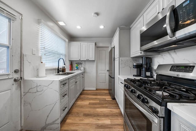 kitchen featuring a sink, stainless steel appliances, tasteful backsplash, and recessed lighting