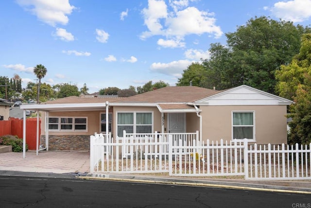 ranch-style house featuring stucco siding and fence private yard