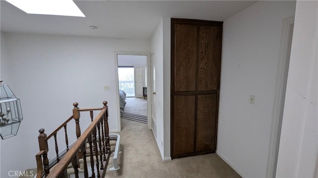 100 S Lucia Ave Unit 1, Redondo Beach, CA 90277 - hallway featuring a skylight, light colored carpet, baseboards, and an upstairs landing