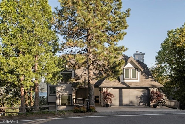 27417 Matterhorn Dr, Lake Arrowhead, CA 92352 - obstructed view of property with concrete driveway, a garage, and a chimney
